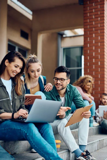 Researchers reviewing academic work together with a laptop and notes